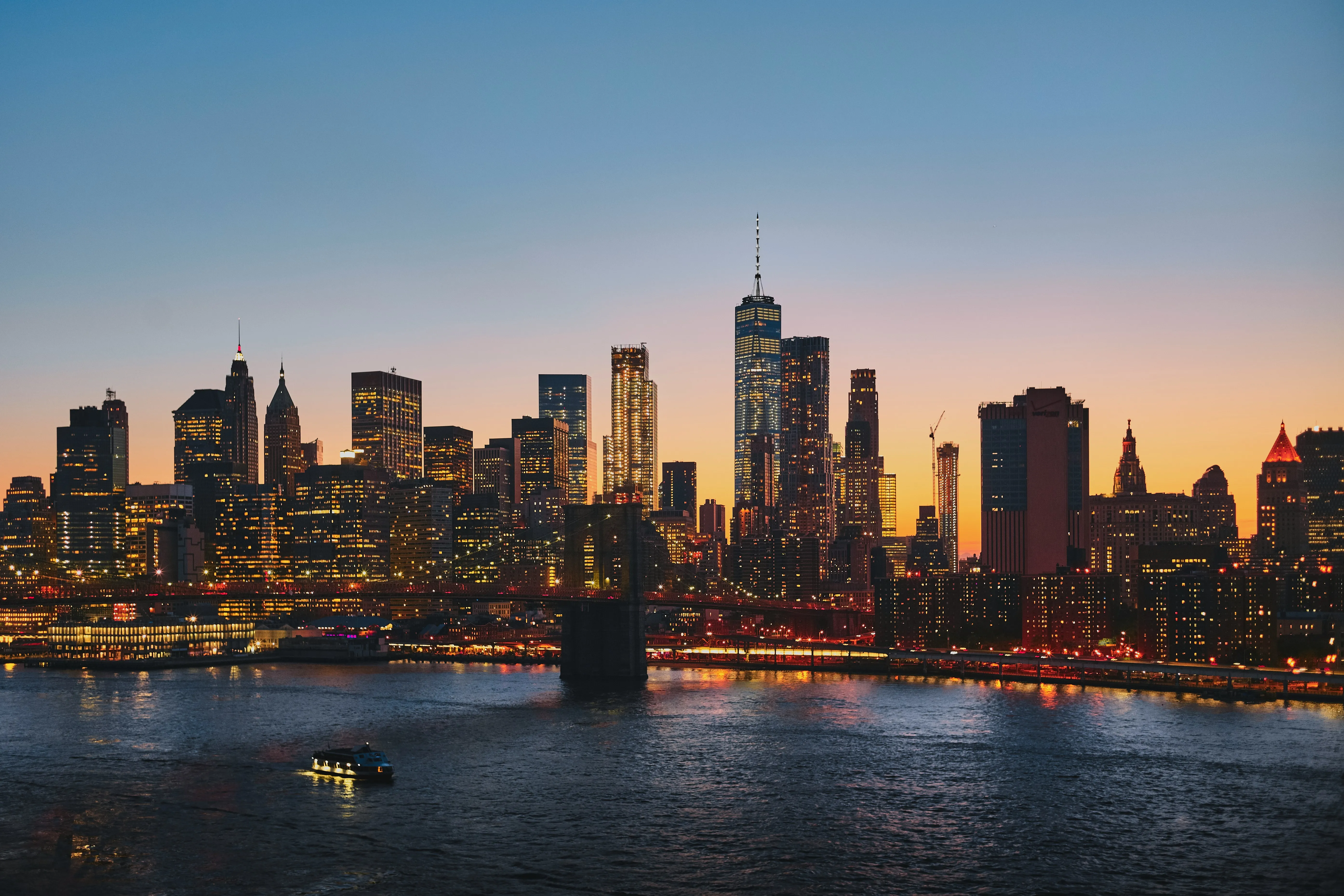 Lower Manhattan and the Brooklyn Bridge at dusk, seen across the East River